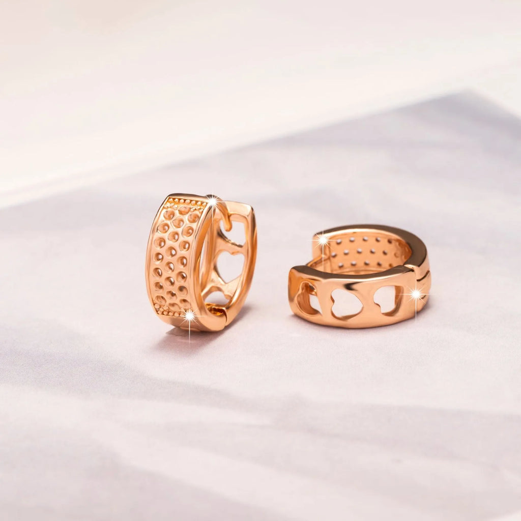 Rose gold heart-shaped women's earrings with three hollowed out sections in a circular design.