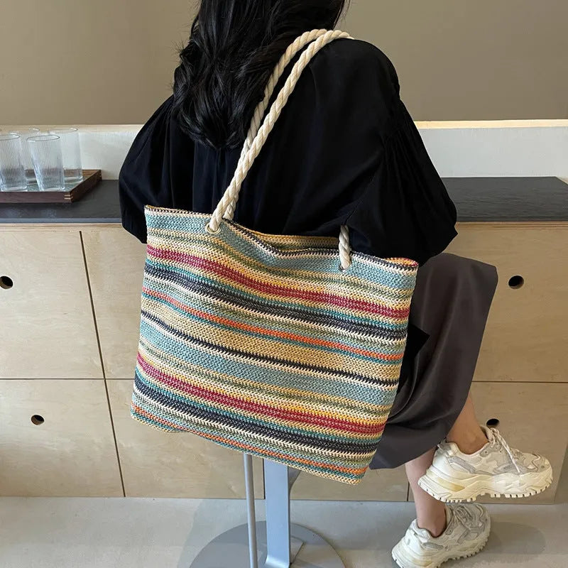Blue woven straw and nylon shoulder bag with a single strap.