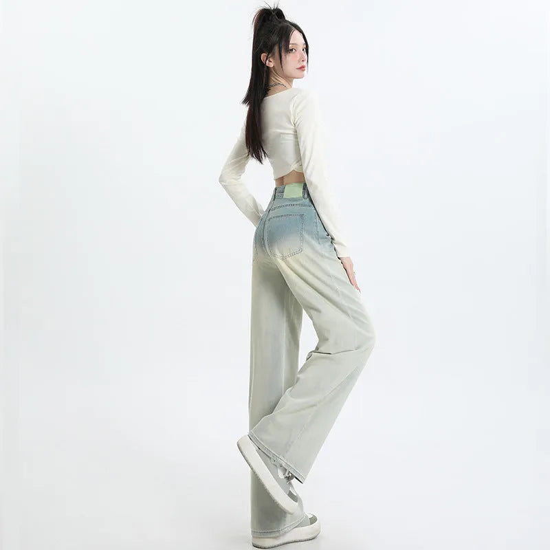 Women's gradient blue denim straight-leg wide-leg trousers laid flat, showing colour fade.