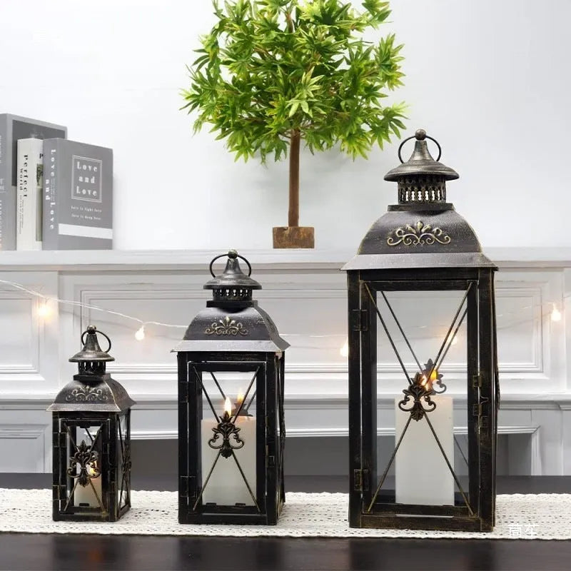 Black and white wrought iron floor-standing storm lantern with tempered glass in three sizes for courtyard use.