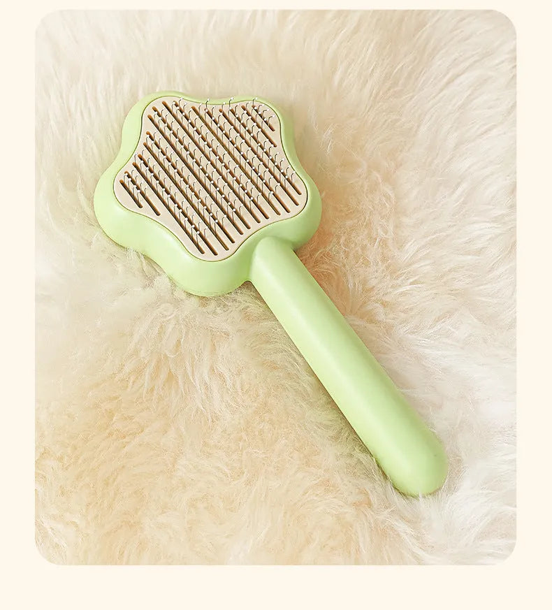 Green self-cleaning cat comb with stainless steel needles measuring 20 cm long