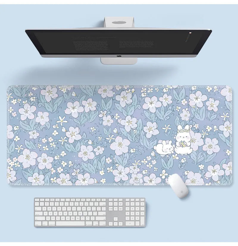 Large floral pattern mouse pad on a desk, showing non-slip rubber base and thin cloth surface.