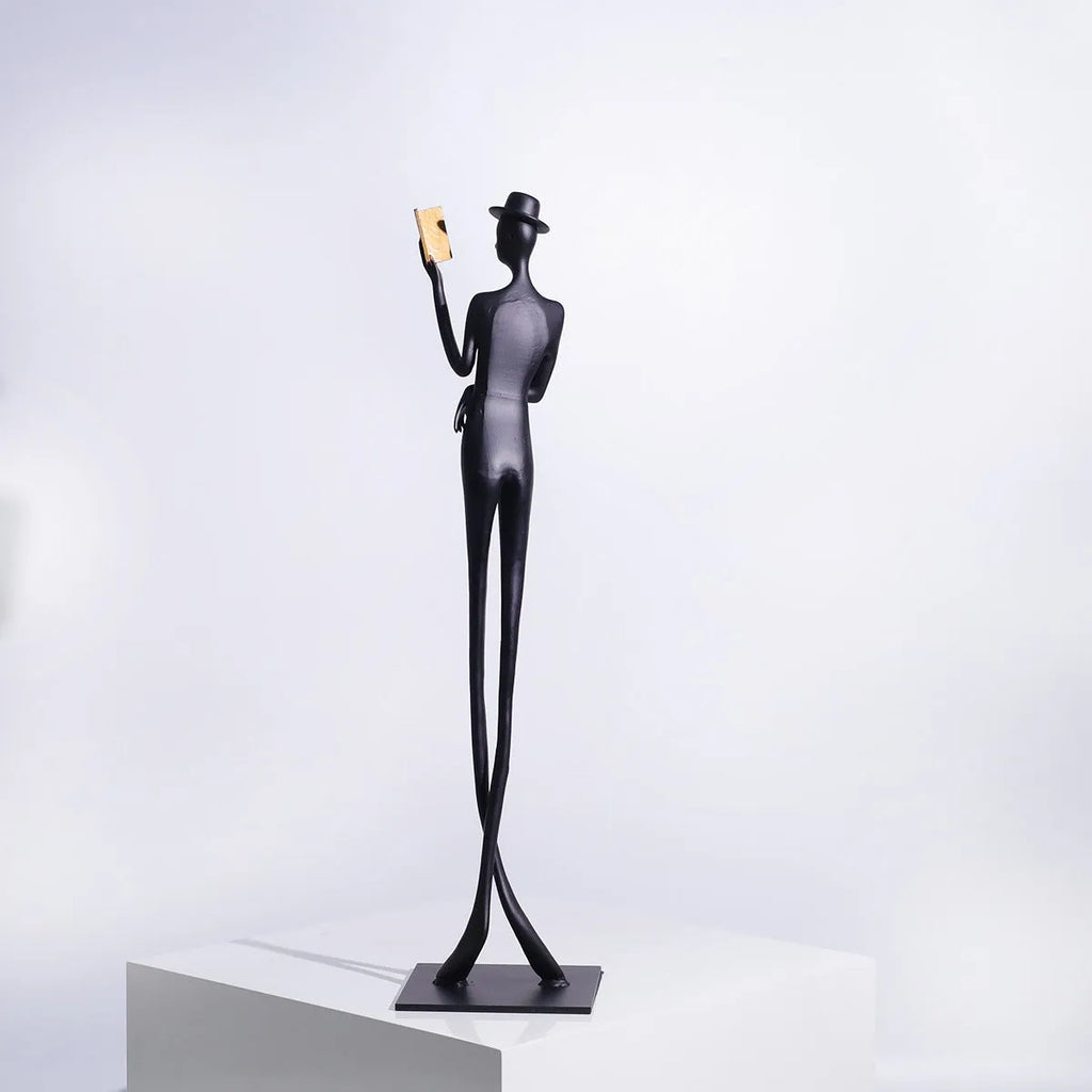 Black aluminium reading woman desk sculpture measuring 12cm by 12cm by 51cm