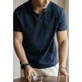 American-style short-sleeved polo shirt in a blue cotton-polyester blend on a hanger.