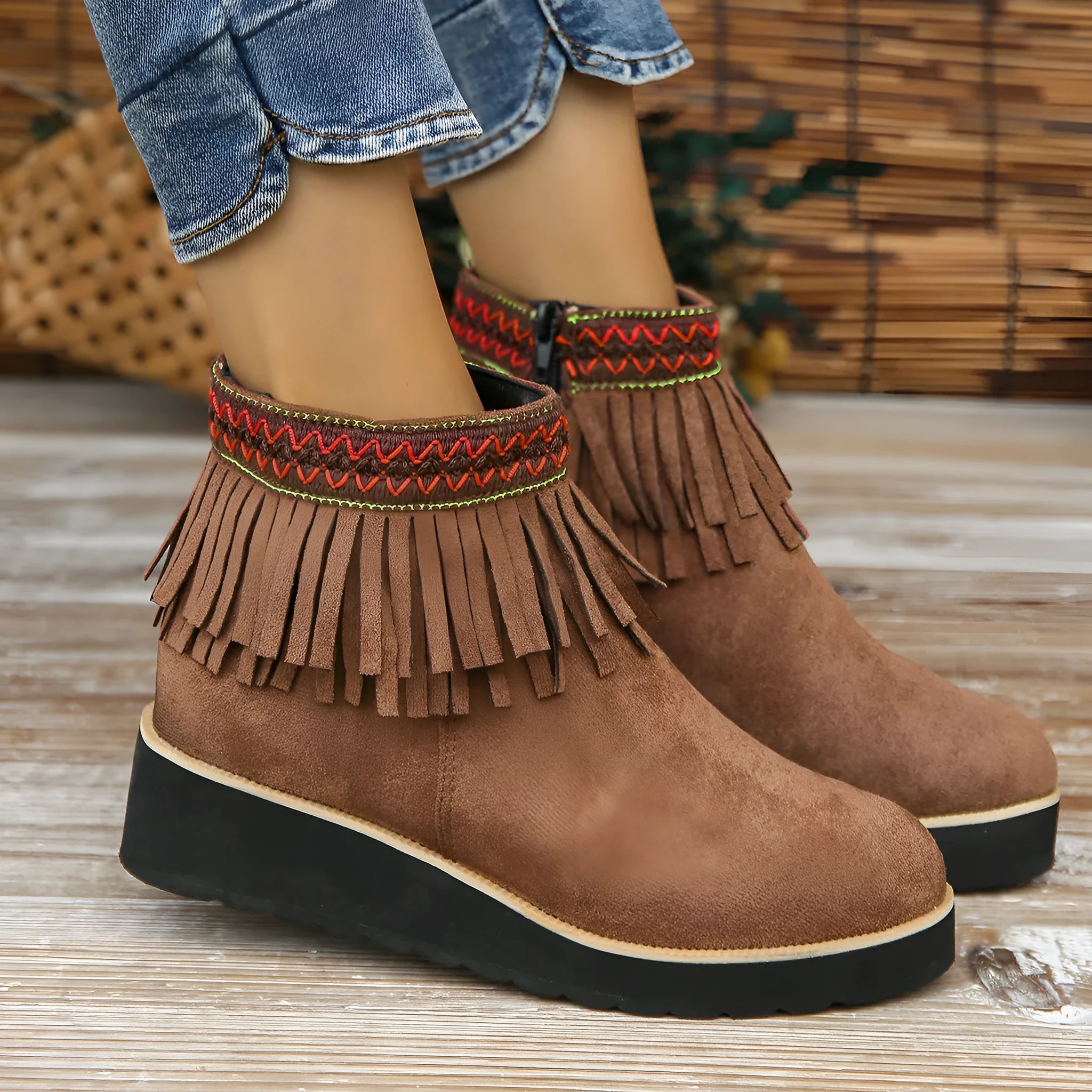 Women's black suede wedge ankle boots with side zipper and decorative tassel on a thick rubber sole.