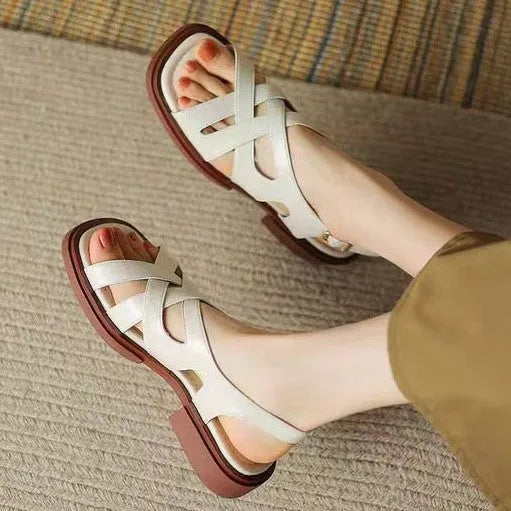 Women's glossy black patent leather beach sandals with square toe and cross-band strap.