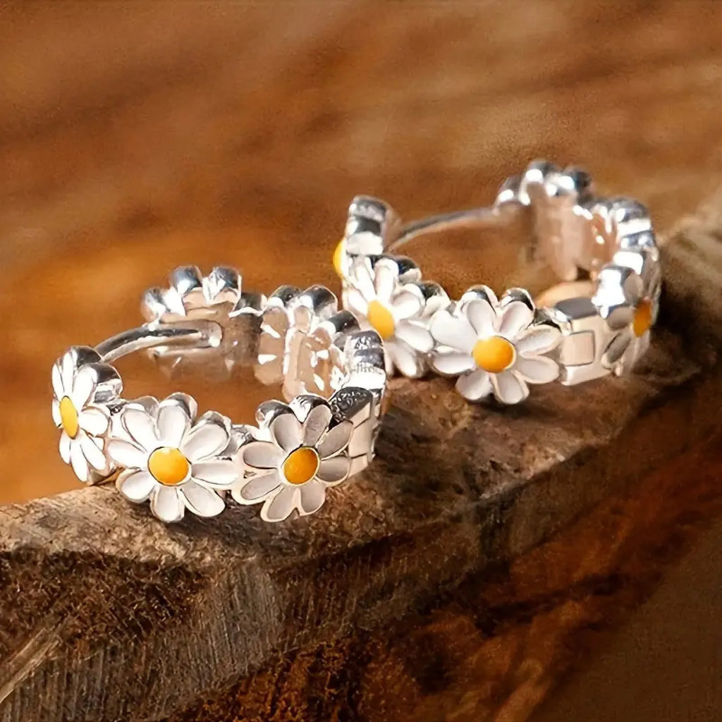 White daisy flower fashion ring earrings with platinum-set gems on a model.