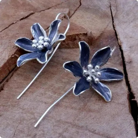 A pair of retro-style purple flower earrings made from lightweight alloy with an electroplated finish.