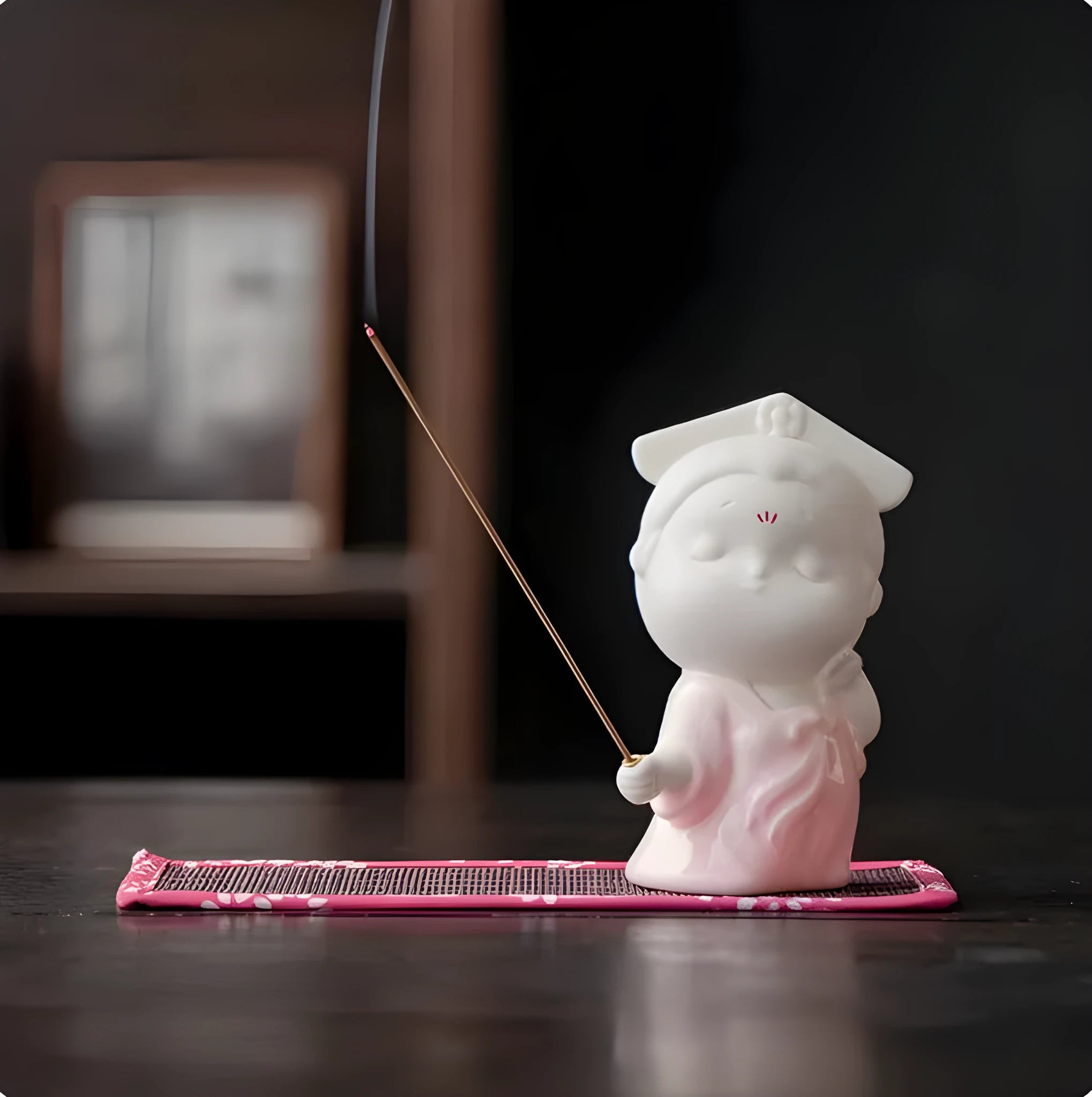 Ceramic cute female court attendant incense burner decoration in hand-painted colours on a shelf.