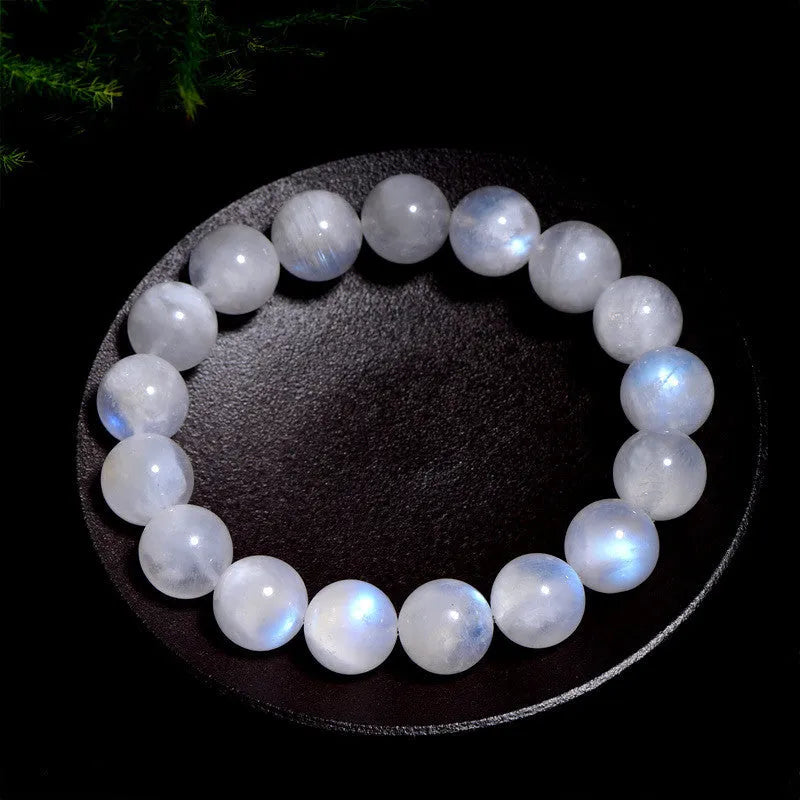 Natural blue moonlight round bead moonstone bracelet on a wrist, showing polished geometric beads.