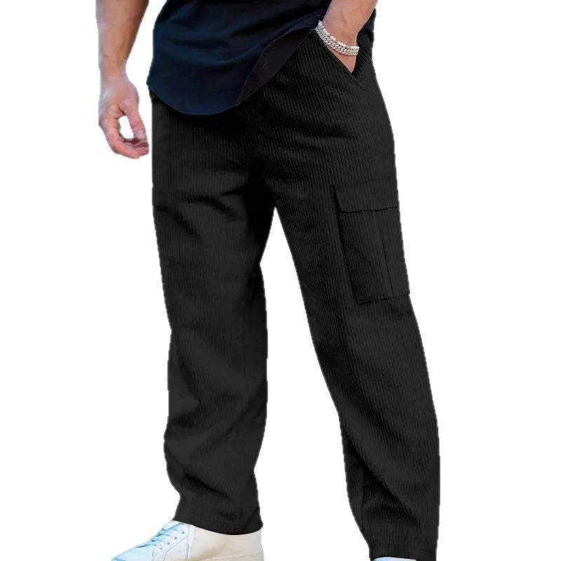 Man wearing loose-fitting navy blue corduroy cargo trousers with a straight leg and drawstring waist.