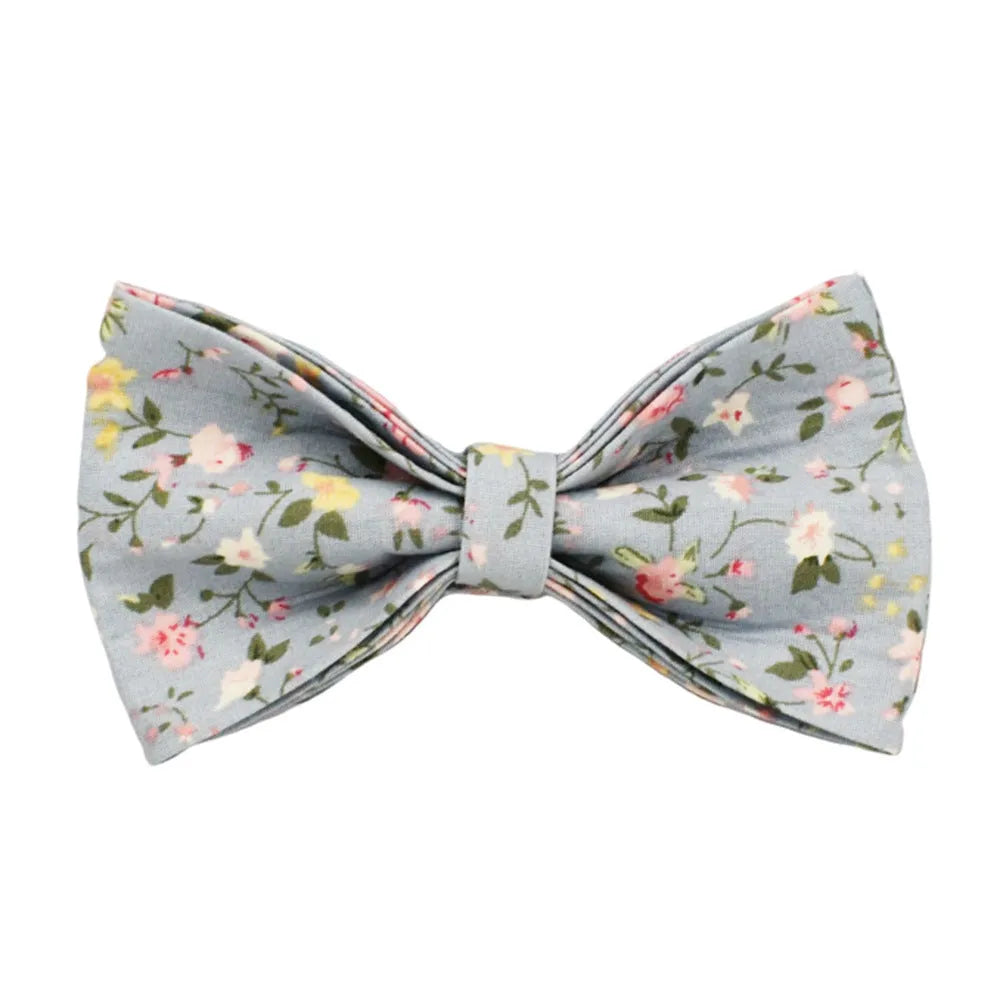 Blue floral patterned dog collar and matching leash, vest, and bow set on a white background.