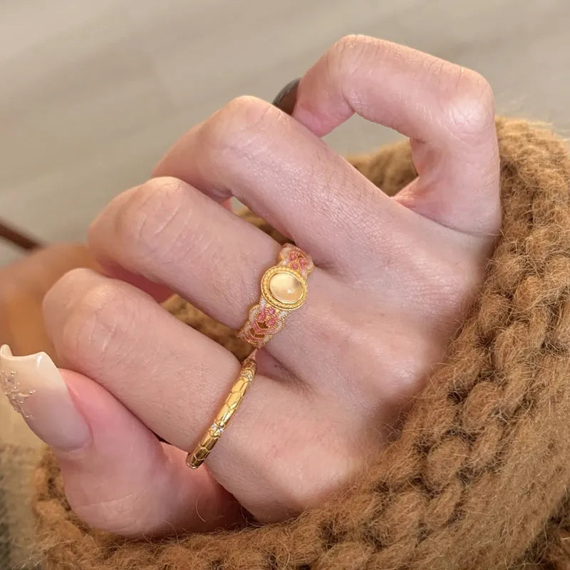 Openable geometric women's ring with pink crystal enamel on a gold plated copper band.