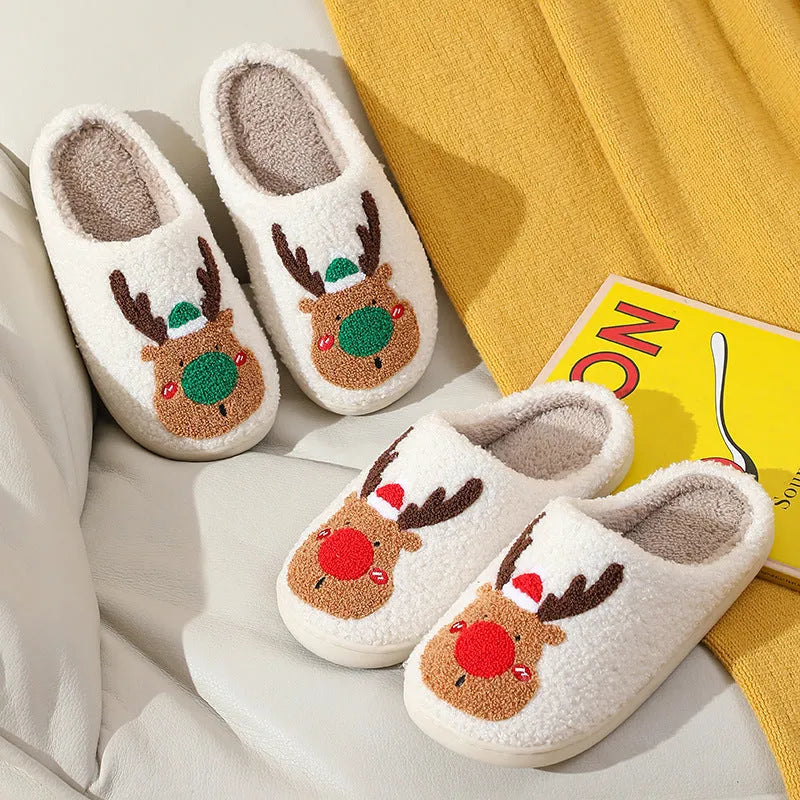 Pair of red Christmas elk plush home slippers on floor, soft anti-slip shoe design