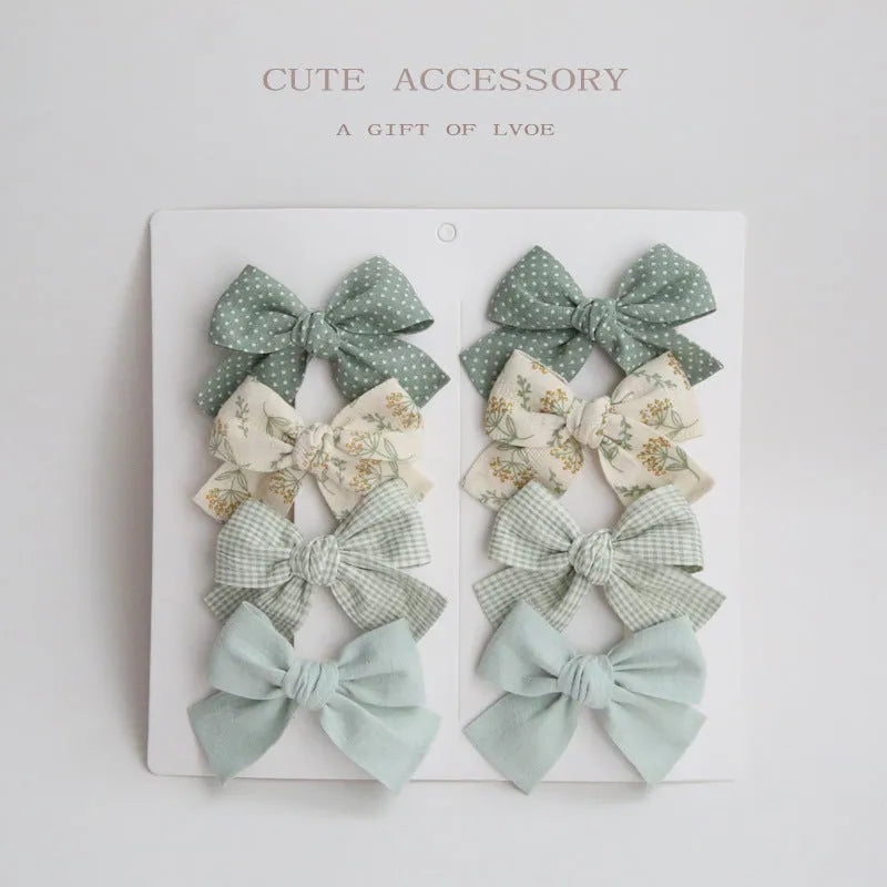 Set of children's fabric hairclips with dovetail bows in eight different colours and patterns.