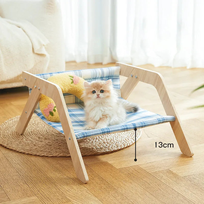 Wooden elevated cat hammock bed with a soft blue cloth sleeping mat, raised on wooden legs.