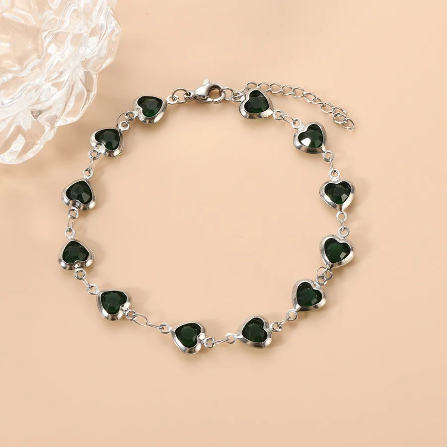 Stainless steel heart-shaped bracelet with electroplated geometric design in various colours like red, blue, and green for unisex wear.