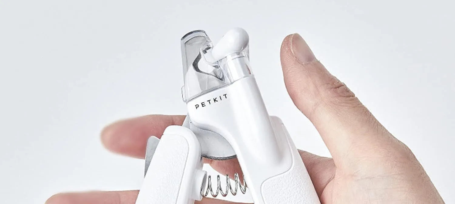White LED pet nail clippers with transparent guard, triangular blade, and anti-slip handle next to a filing tool.