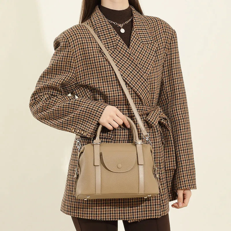 Genuine leather ladies handbag with lock detail in black, brown, or elephant grey.