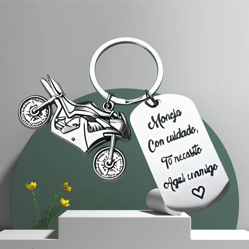 Stainless steel keychain with a motorcycle design presented on a velvet cloth.