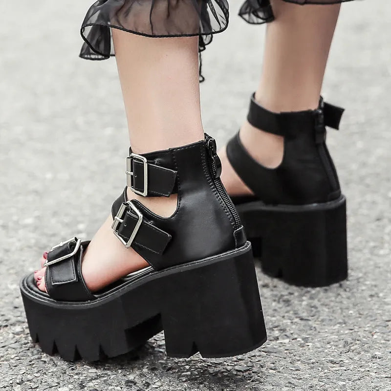 Black women's punk-style sandals with chunky heel, platform sole, buckle, and back zipper.