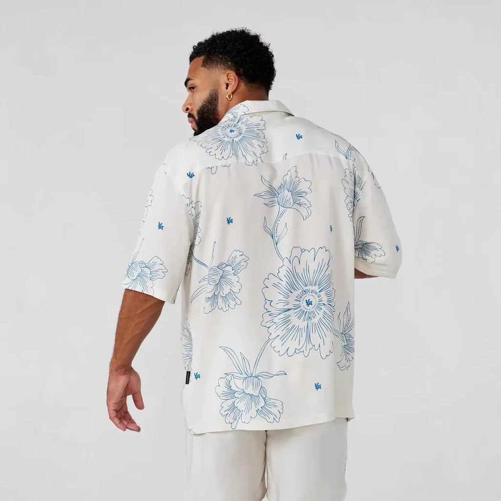 Man wearing a loose, short-sleeve printed cardigan top in a floral pattern.