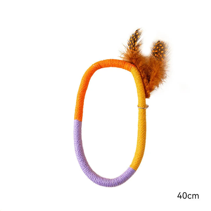 Green circular cotton rope cat toy with white feathers attached for chewing and interactive play.