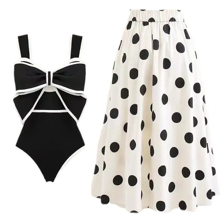 Women's black one-piece swimsuit with a white round skirt and a central bow detail.