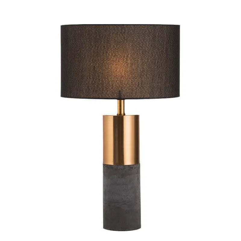 Simple designer industrial style table lamp in dark gray on a wooden desk with ambient lighting