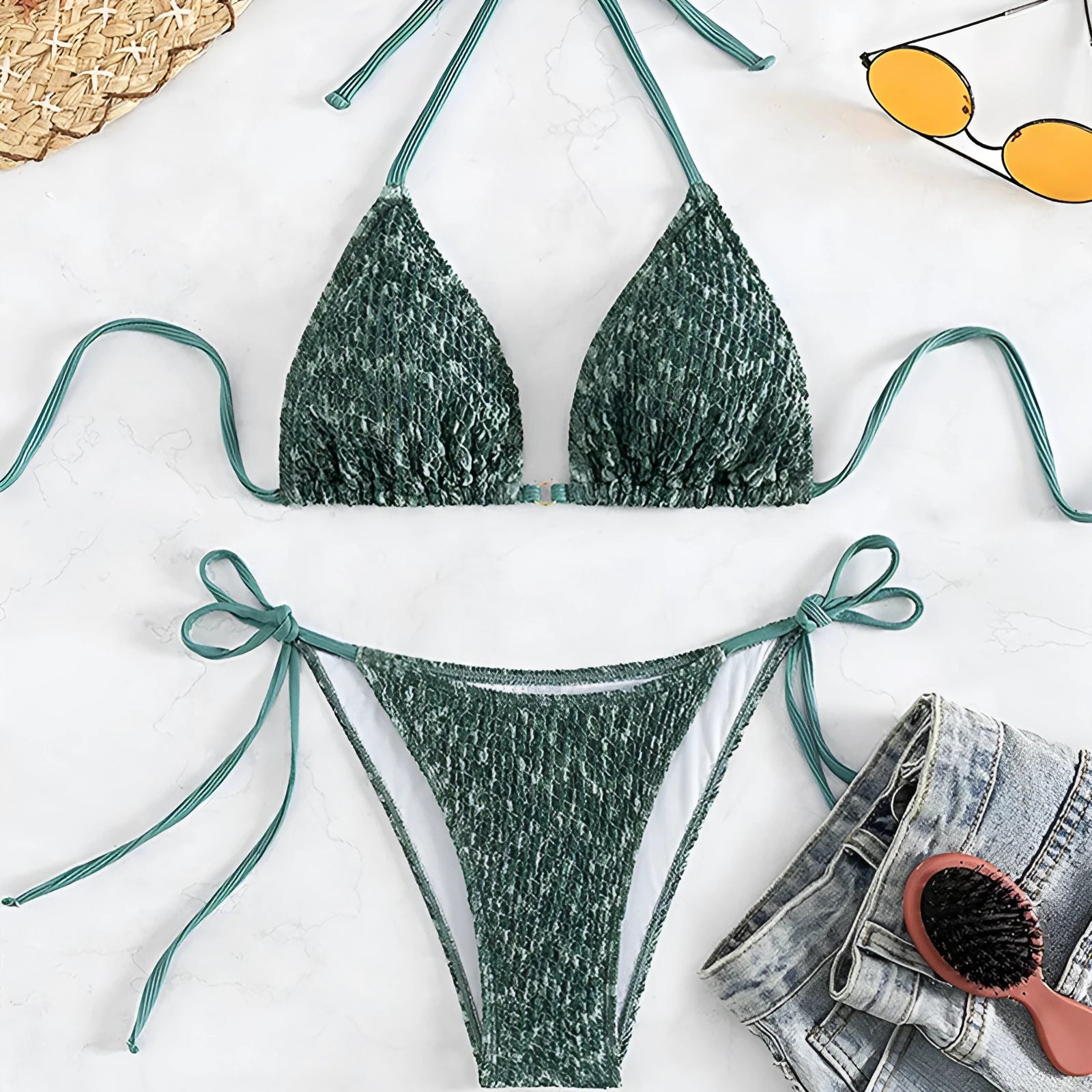 Green women's backless halter bikini set with shorts on a mannequin.