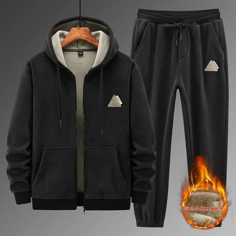 Man wearing a grey hooded cashmere sweater and matching cotton trousers from a casual sports suit.