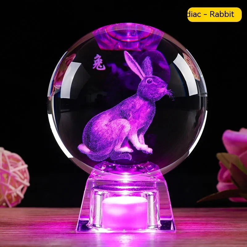 White crystal ball luminous ornament with Chinese zodiac animal design on an electronic charging base.