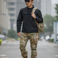 Bone Frog Peak Breaker soft shell tactical jacket in black, shown in outdoor setting.