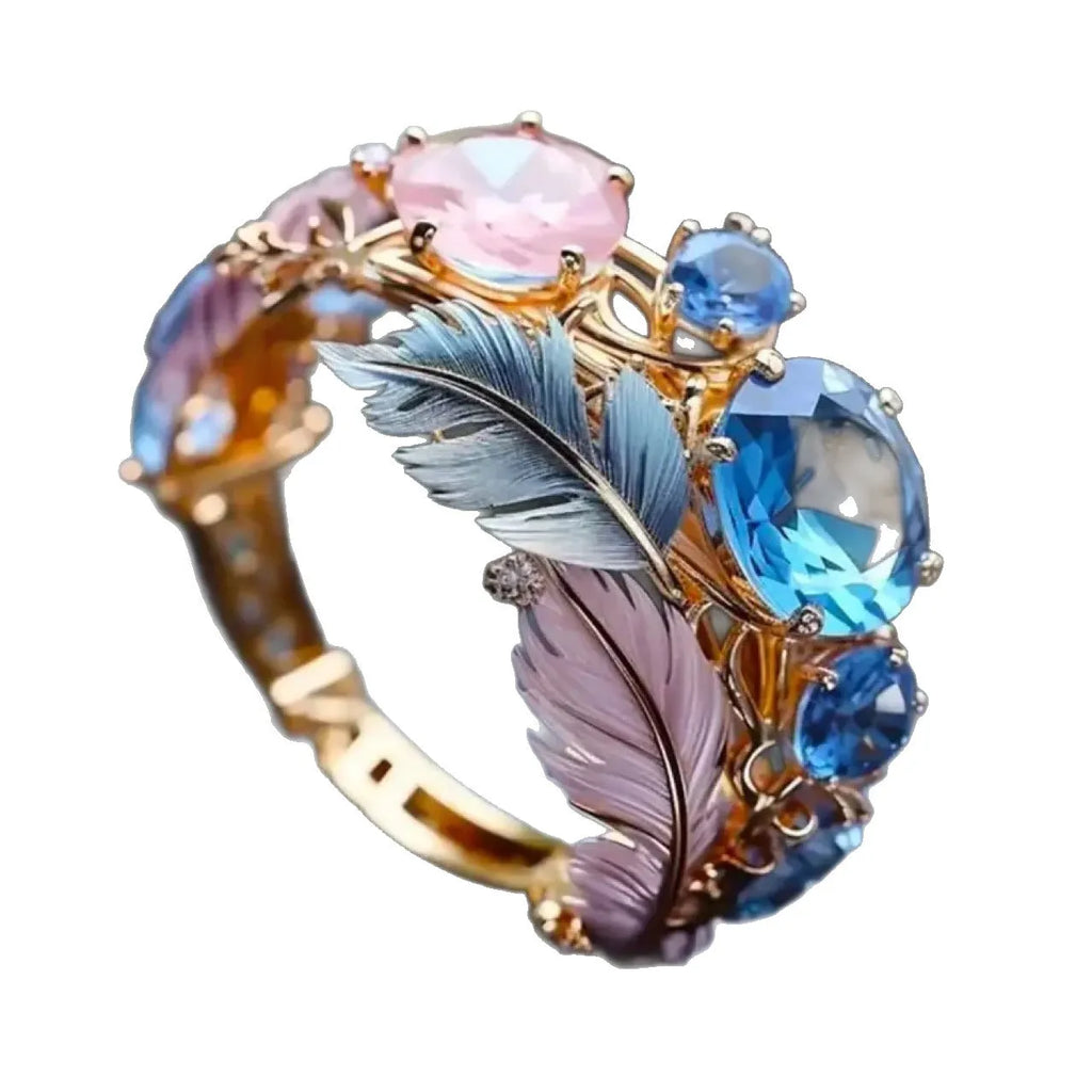 Gold colour brass ring with embossed feather design and cubic zirconia stone.