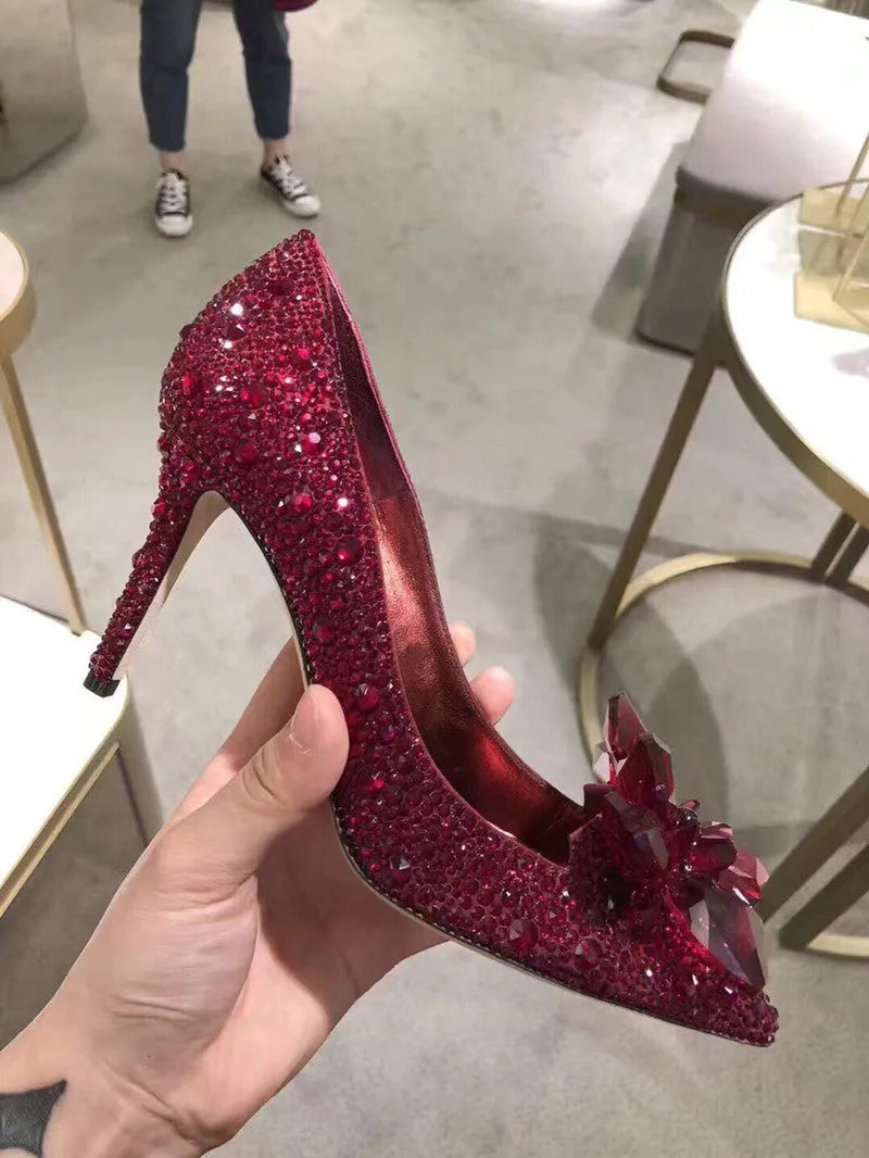 Women's gold pointed toe stiletto high heels with sequin cloth and rhinestone decoration.