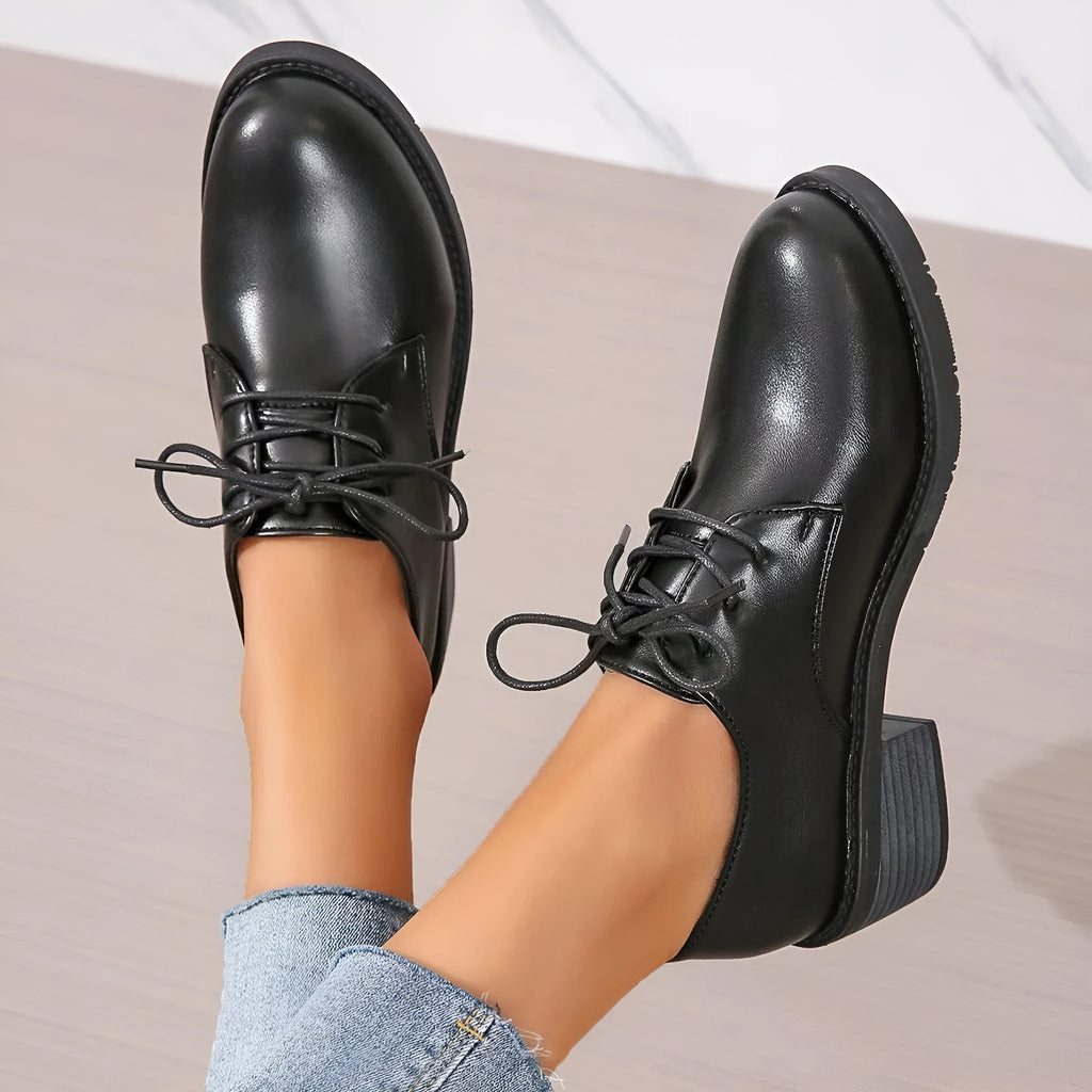 Black women's low-top work shoes with a chunky rubber heel and pointed toe.
