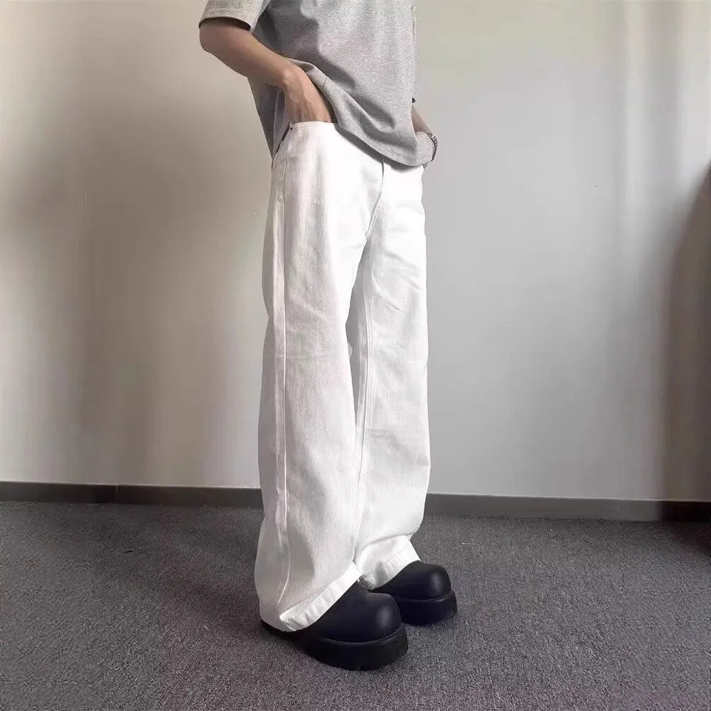 A pair of men's straight-leg white jeans with a mid-rise waist and zipper fly on a plain background.