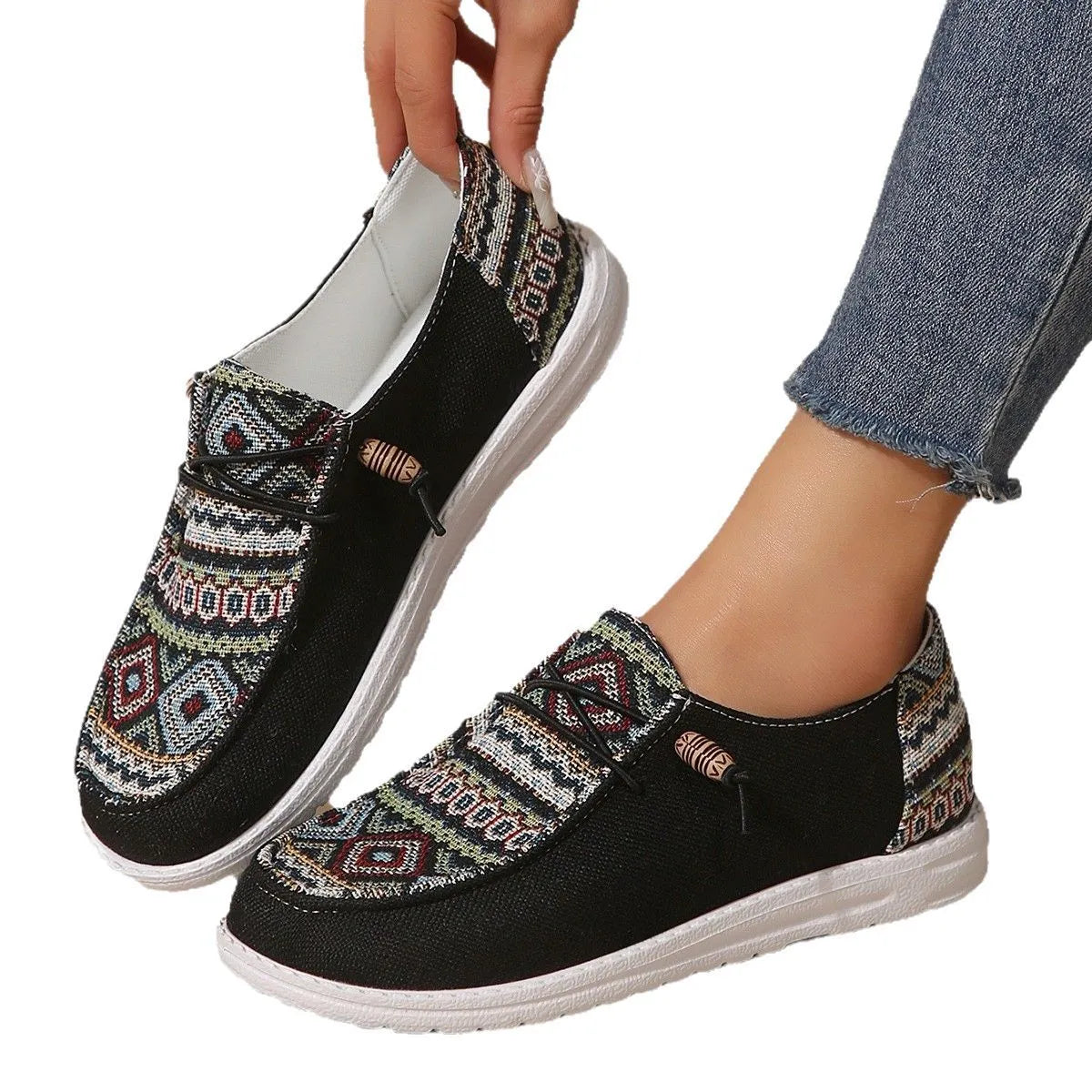 Women's black flat slip-on shoes with round toe and rubber sole on a neutral background.