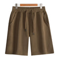 Men's and women's straight-leg cotton sports shorts in fifth length on a neutral background