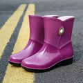 Women's mid-length PVC rain boots in purple, black, or beige with non-slip sole