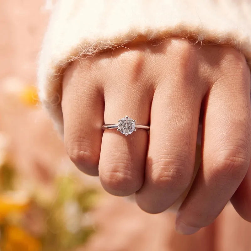 Simple classic 6 claw 1 karat moissanite ring in silver on white background, US size 7