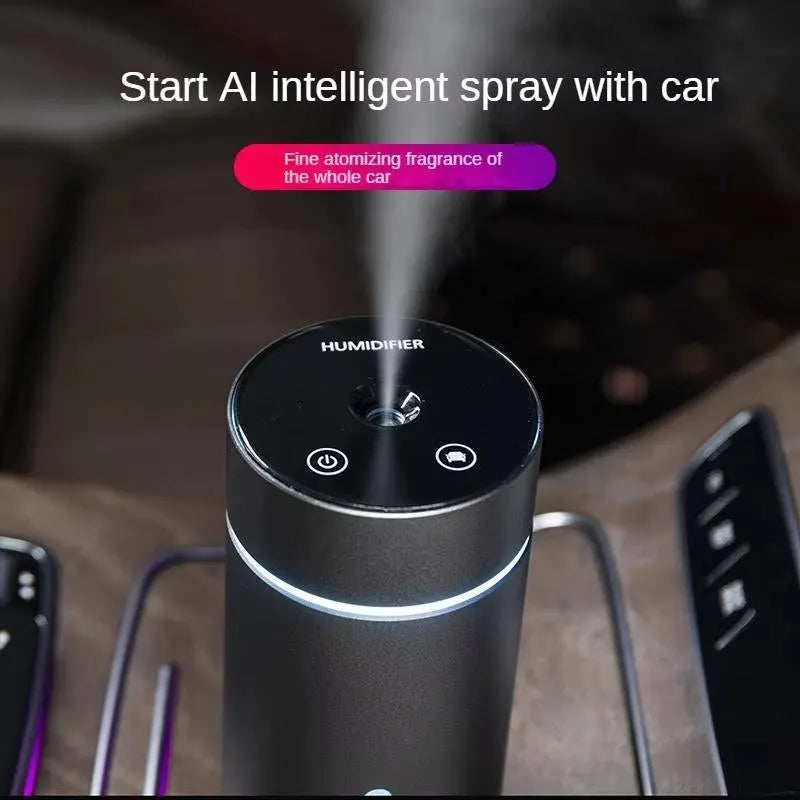 Black aluminium car humidifier and essential oil diffuser with night light on a desk next to USB cable.