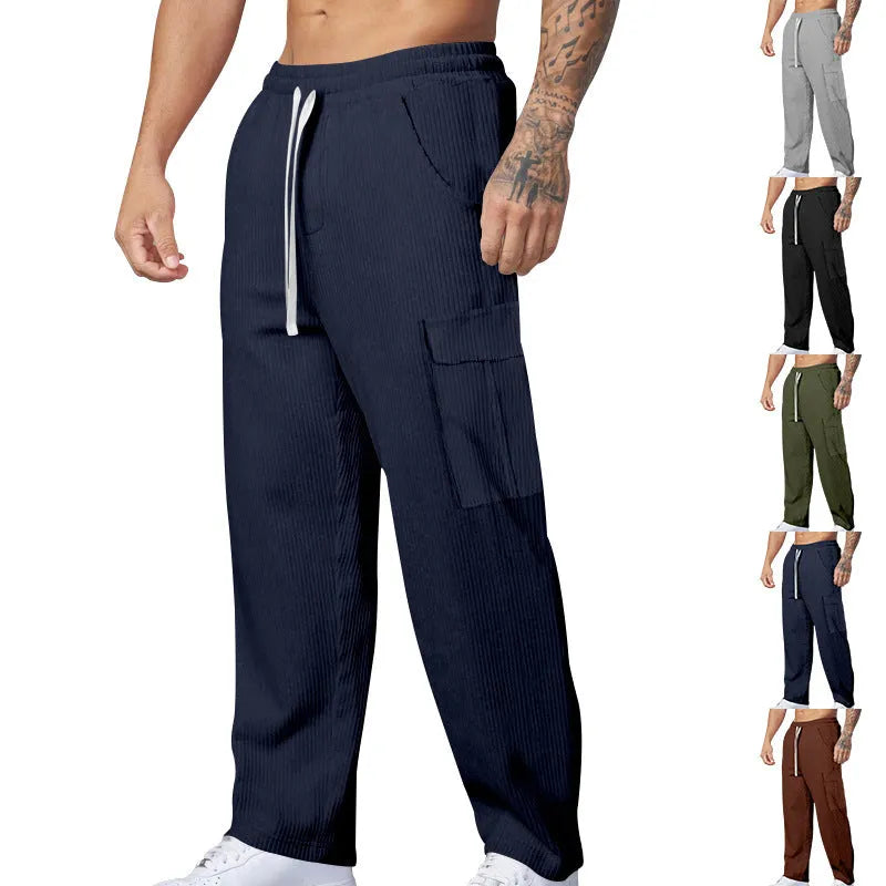 Man wearing loose-fitting navy blue corduroy cargo trousers with a straight leg and drawstring waist.