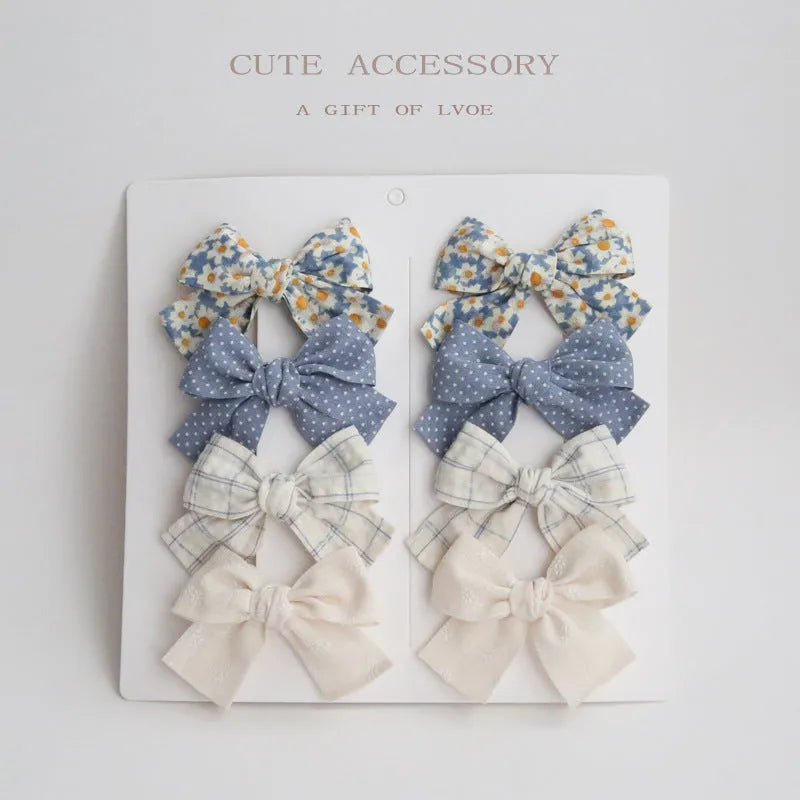 Set of children's fabric hairclips with dovetail bows in eight different colours and patterns.