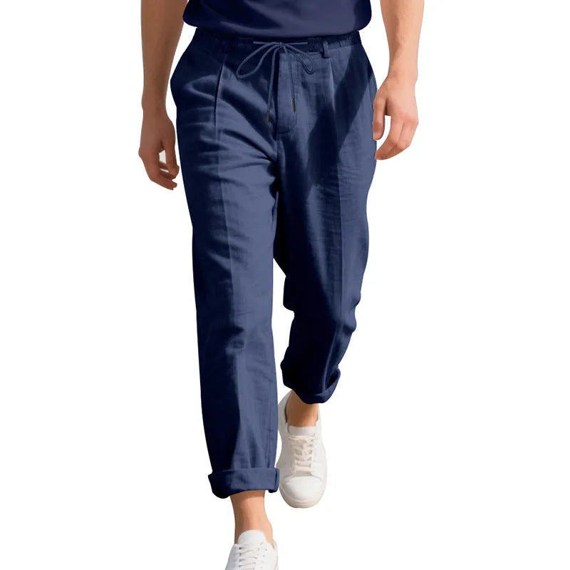 Man wearing light khaki linen casual trousers with a drawstring waist and straight leg.