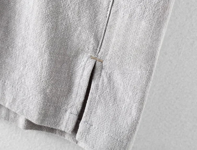 A man's loose-fit linen casual shirt in a solid colour, shown in light grey, featuring long sleeves and a button front.