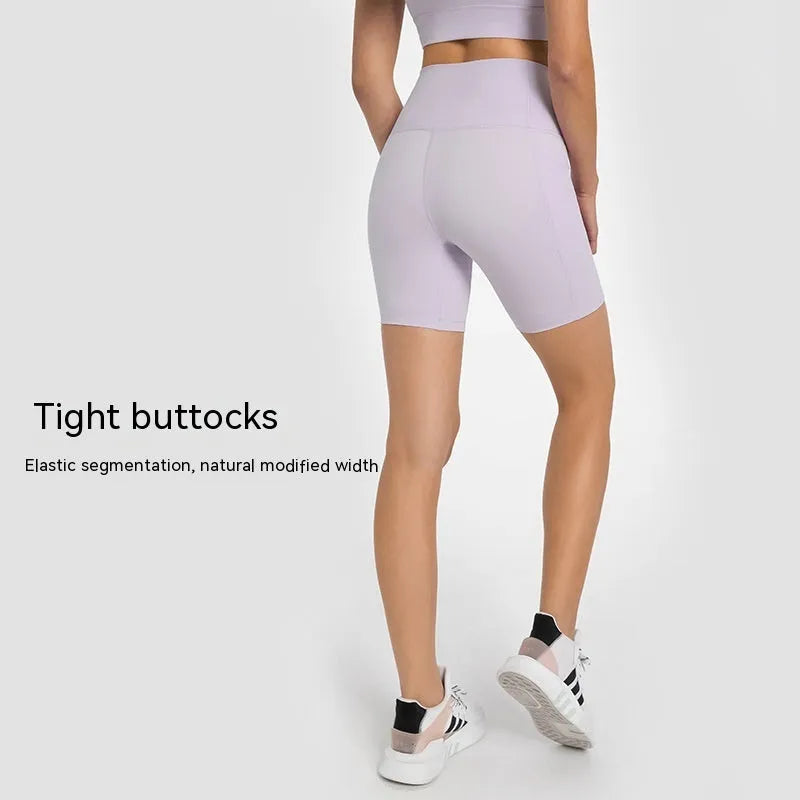 Women's tight-fit cotton blend sports shorts in short fifth pants length on a neutral background.