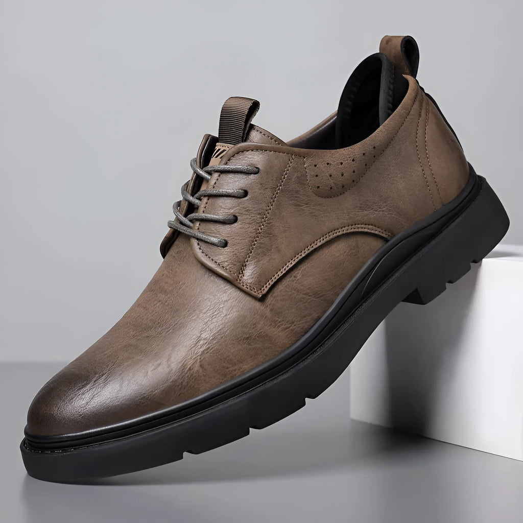 Men's black and brown leather casual sneakers with visible sewing line detail on the cowhide upper.