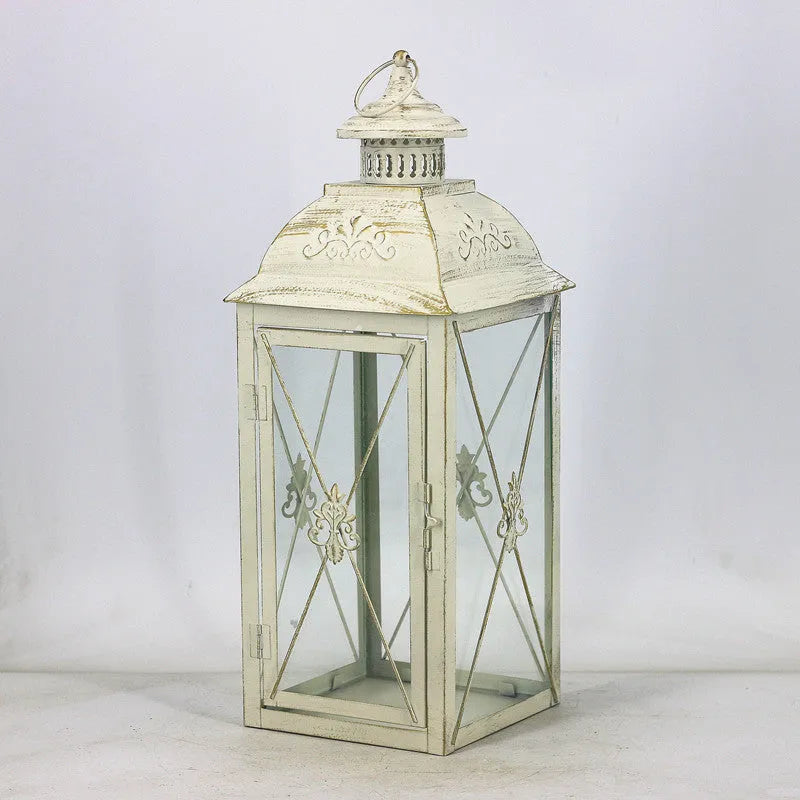 Black and white wrought iron floor-standing storm lantern with tempered glass in three sizes for courtyard use.