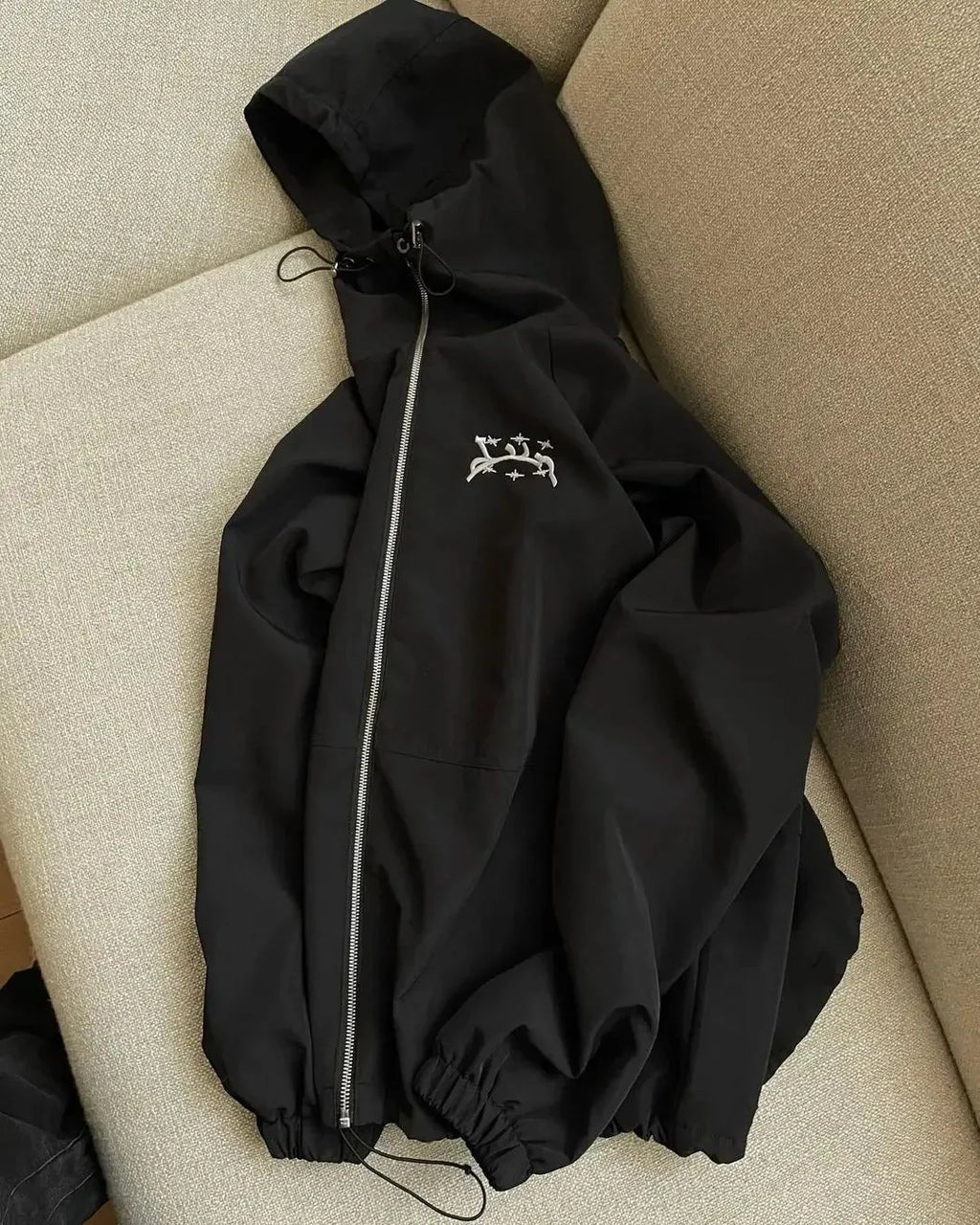 Grey loose fit men's hooded sunscreen jacket hanging, showing front design and hood.